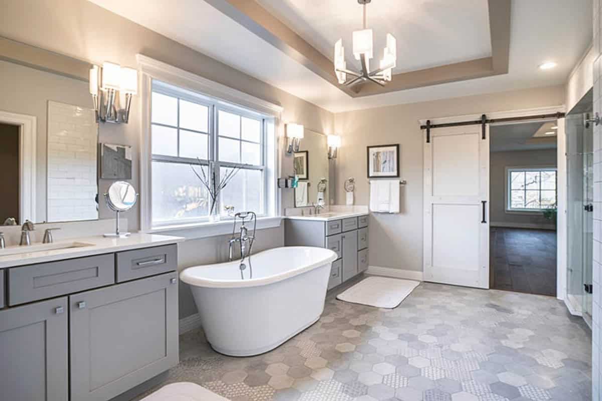 Gorgeous contemporary bathroom with his and hers gray sink vanities & tub
