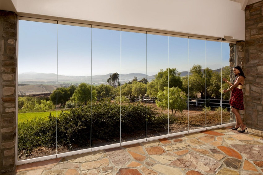 Woman standing near frameless glass NanaWall folding door